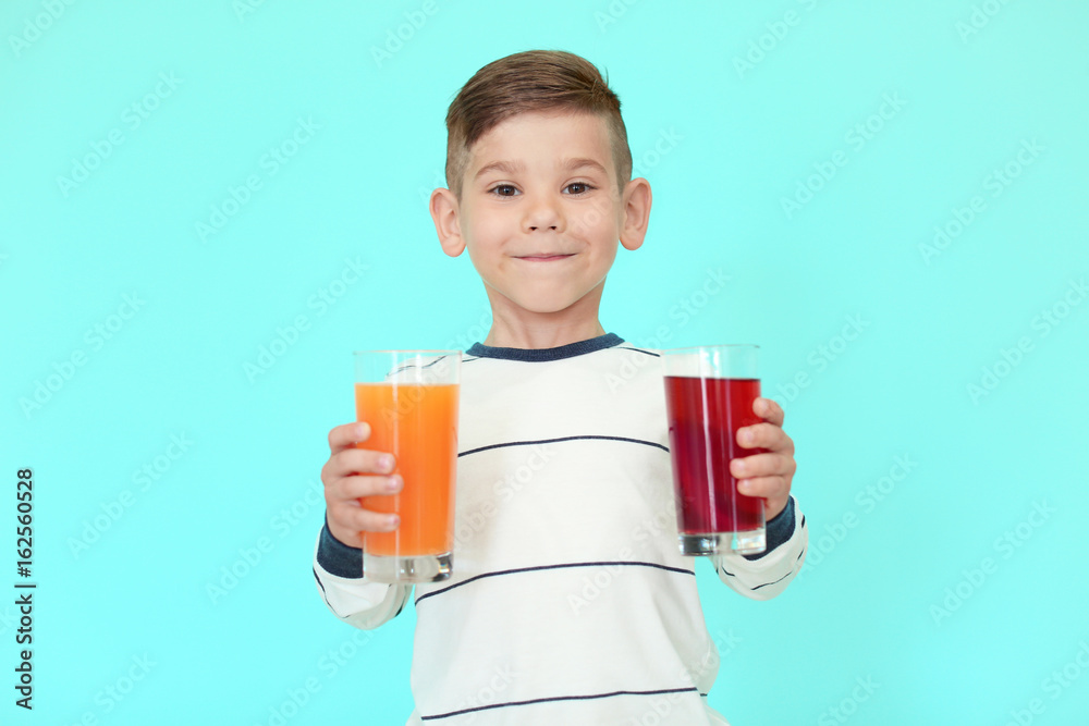 Cute little boy with glasses of juice on color background Cute little boy with glasses of juice on color background