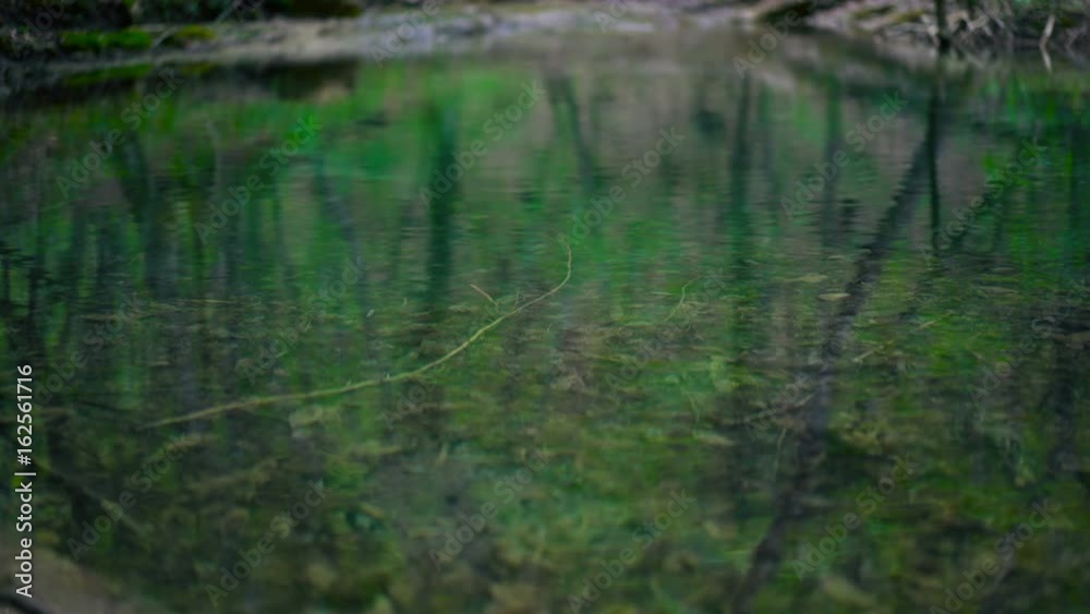 Small mountain river backwater in stony riverbed. Calm water. Crimea mountains in spring. 4K UHD Small mountain river backwater in stony riverbed. Calm water. Crimea mountains in spring. 4K UHD
