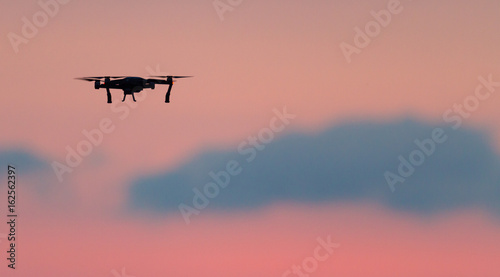 Drone flies over a colourful sunrise sky.