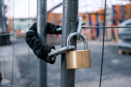 chain and padlock on gate at construction site photo