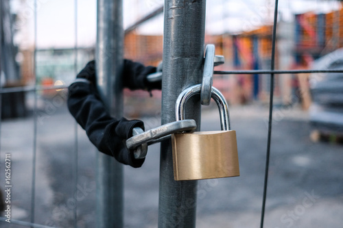 Fotografie chain and padlock on gate at construction site