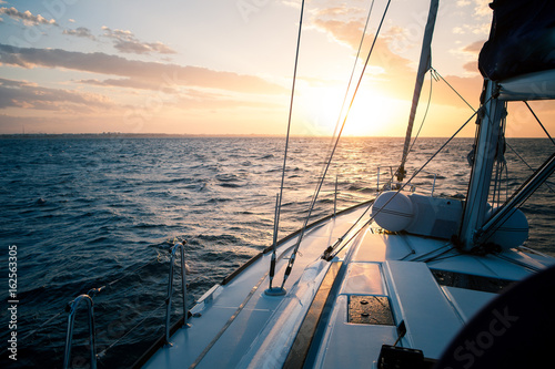 Fototapeta Naklejka Na Ścianę i Meble -  Sailing yacht at sunset in the open sea