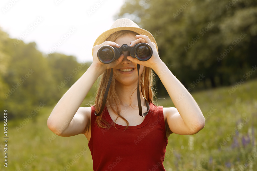 Young girl on nature with hat and binocular. Summer Young girl on nature with hat and binocular. Summer