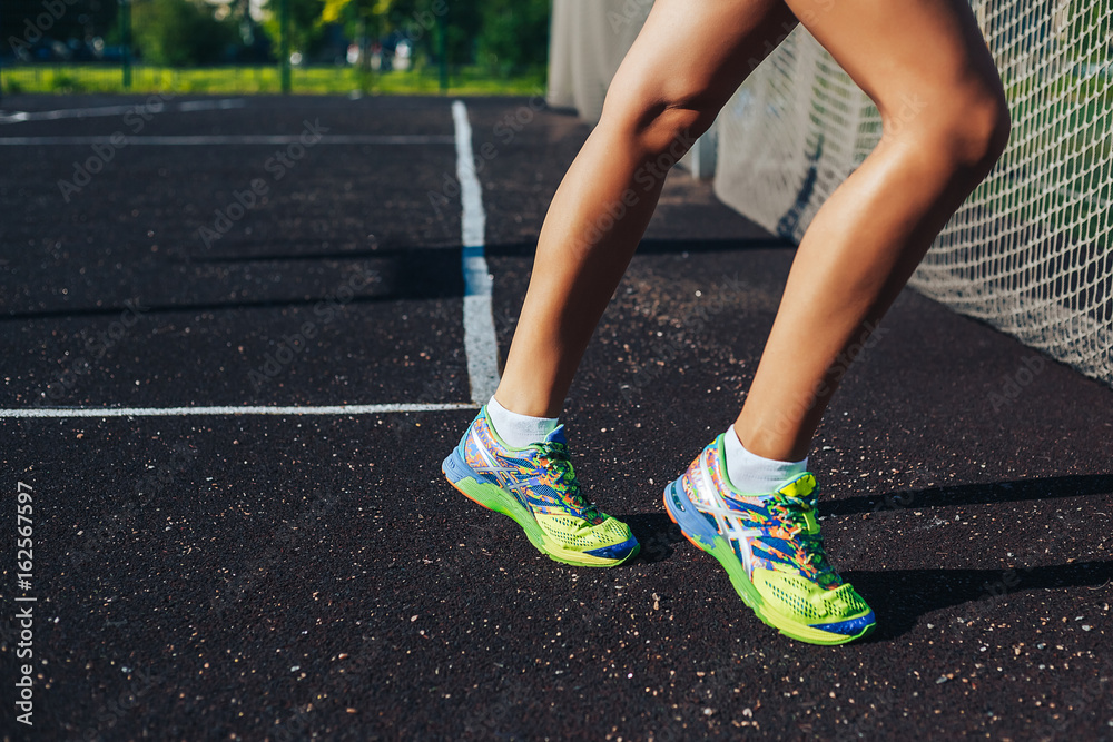 Athlete runner feet running on road closeup on shoe. woman fitness sunrise jog workout wellness concept.