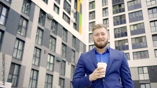 Wallpaper Mural American businessman walking in the city, drinking coffee to switch independently between the buildings of the glass smiling Torontodigital.ca