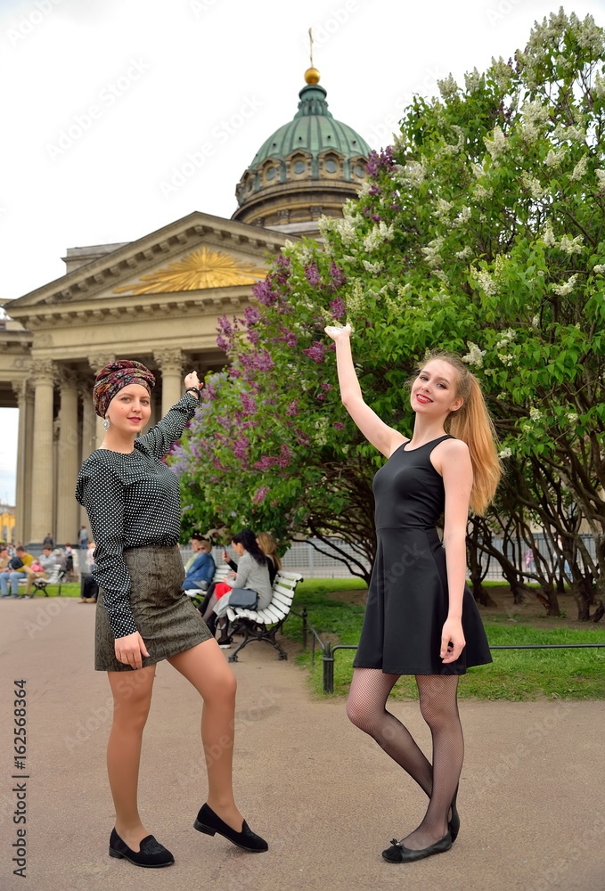 Beautiful girls show up on the Kazan Cathedral and the blossoming lilac