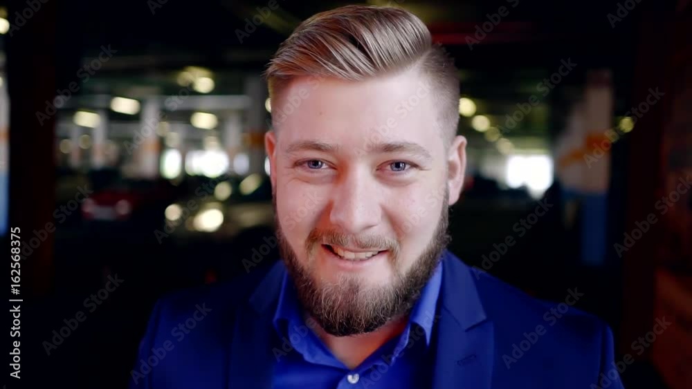 Closeup portrait of young business man with a beard. To touch her face with his hand. Dark background city Parking. Closeup portrait of young business man with a beard. To touch her face with his hand. Dark background city Parking.