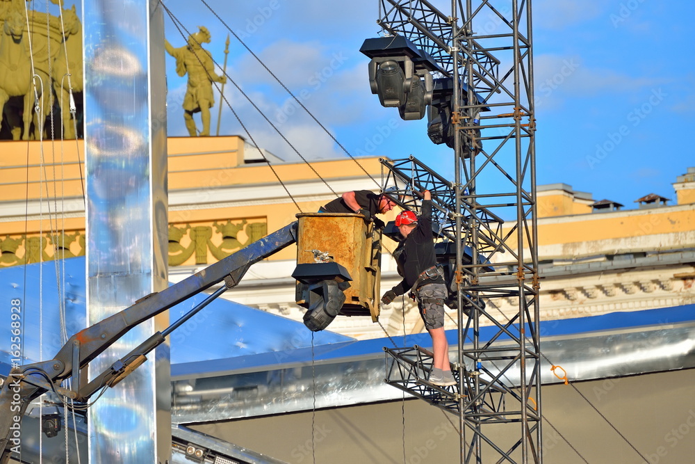 Workers assemble the floodlights on the mast for the holiday Scarlet Sails on the Palace square in Saint-Petersburg