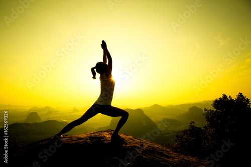 young fitness woman meditating on sunrise mountain peak © lzf