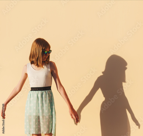 the girl holds the hand of her shadow