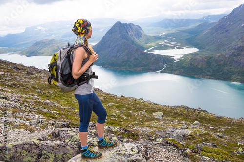 Sport woman hiking on Besseggen. Hikers enjoy beautiful lake and good weather in Norway.