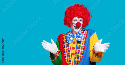 Closeup portrait of a clown on a blue background Fototapete