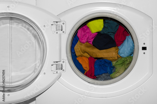 Washing machine, colorful clothes. Pile of laundry.