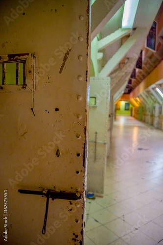 Cuadro en lienzo Indoor view of old deserted rugged building, metal door in the old prison Penal