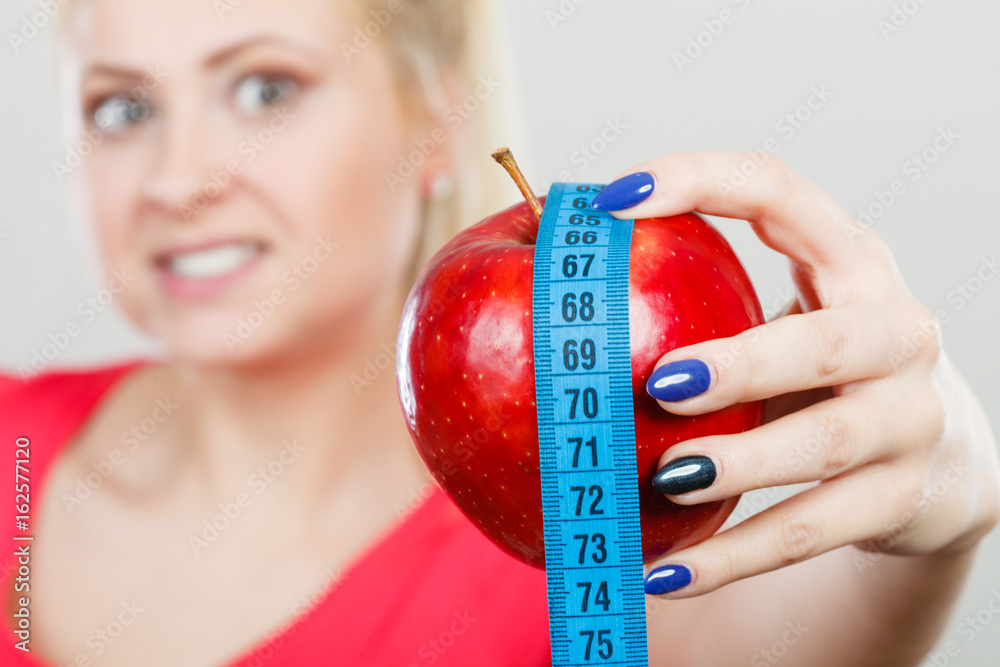 Happy woman holding apple and measuring tape Happy woman holding apple and measuring tape