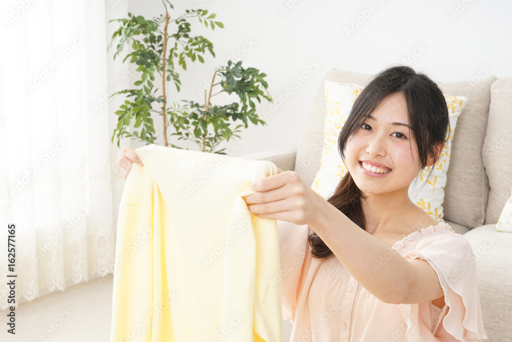 Young woman folding her clothes Young woman folding her clothes