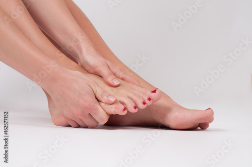 Female legs. Woman massaging her foot