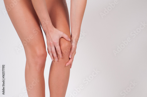  Woman massaging her painful knee, feeling pain in knee. © Dmytro Flisak