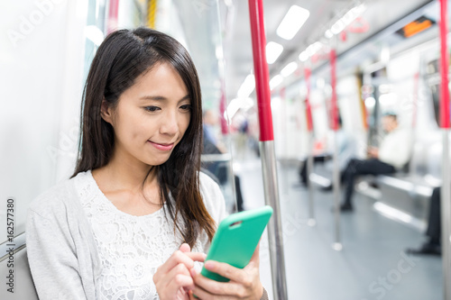 Woman use of smart phone inside subway