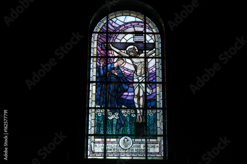 ROME, ITALY - JUNE 11, 2017: A Stained glass of the cruxificcion of Jesus is seen at Basilica di Santi Giovanni e Paolo