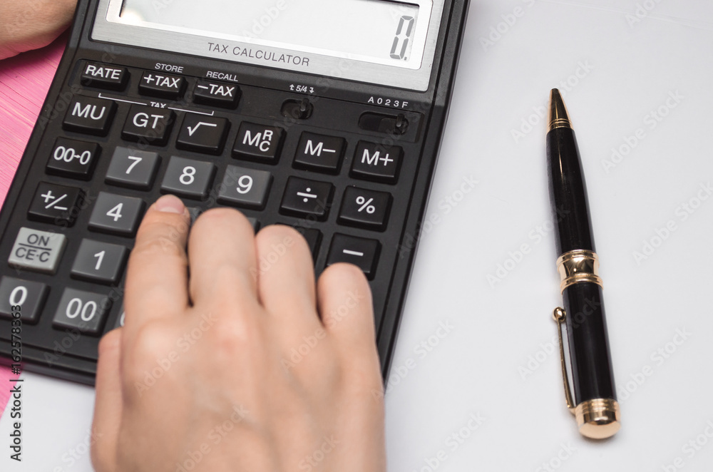 Female hands, blank page, pen and calculator on wooden desk table mock up. Business or education concept. Female hands, blank page, pen and calculator on wooden desk table mock up. Business or education concept.