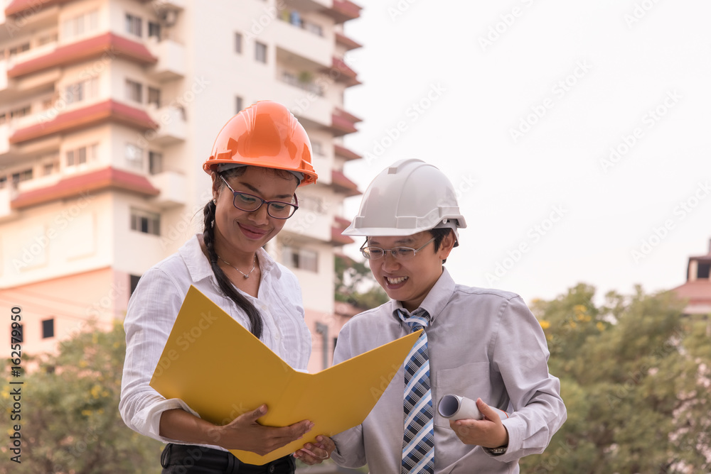 Smiling civil engineer and architect working in a construction site Smiling civil engineer and architect working in a construction site