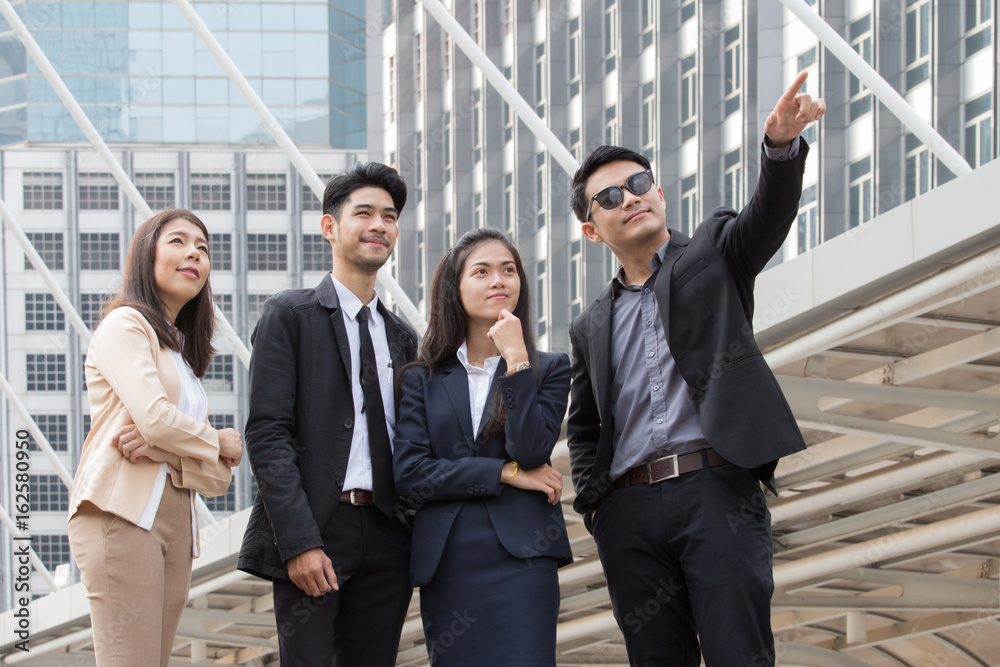 Business people talking outside the office with happy face with city background Business people talking outside the office with happy face with city background