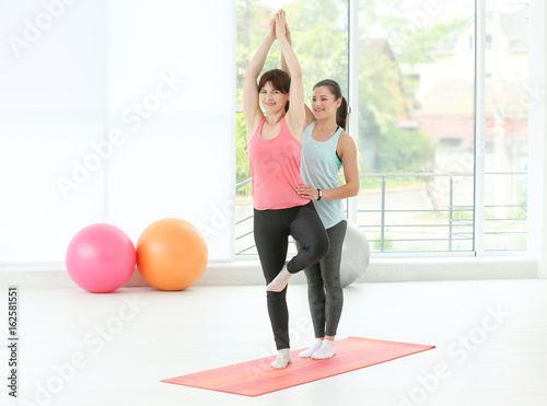Instructor helping woman to...