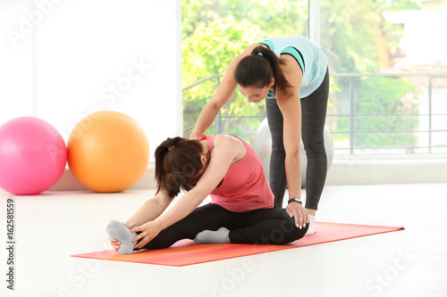 Instructor helping woman to...