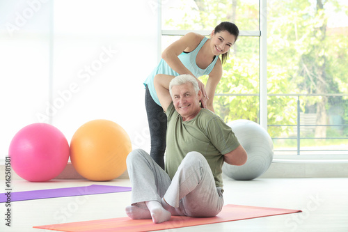 Instructor helping senior m...
