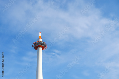 Telecommunication tower antenna with clear blue sky.