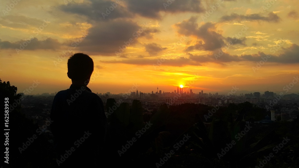 Silhouette of young boy during sunset in kuala lumpur city