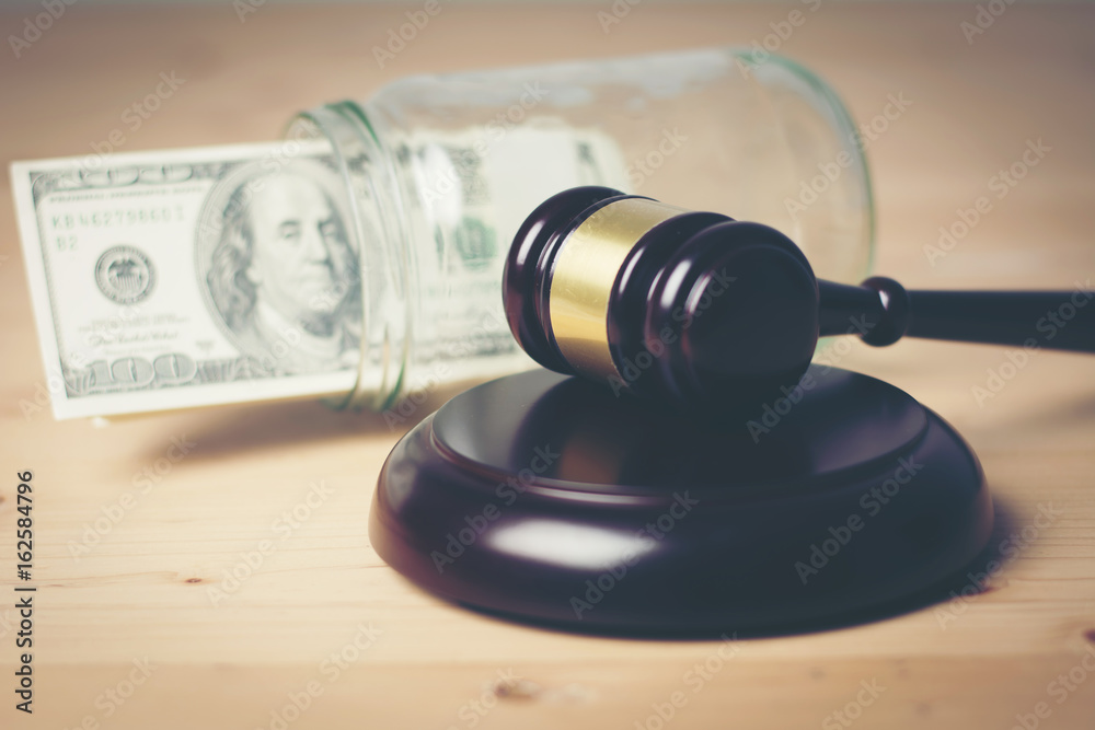 Concept of Legal court gavel on assorted cash, Close up.