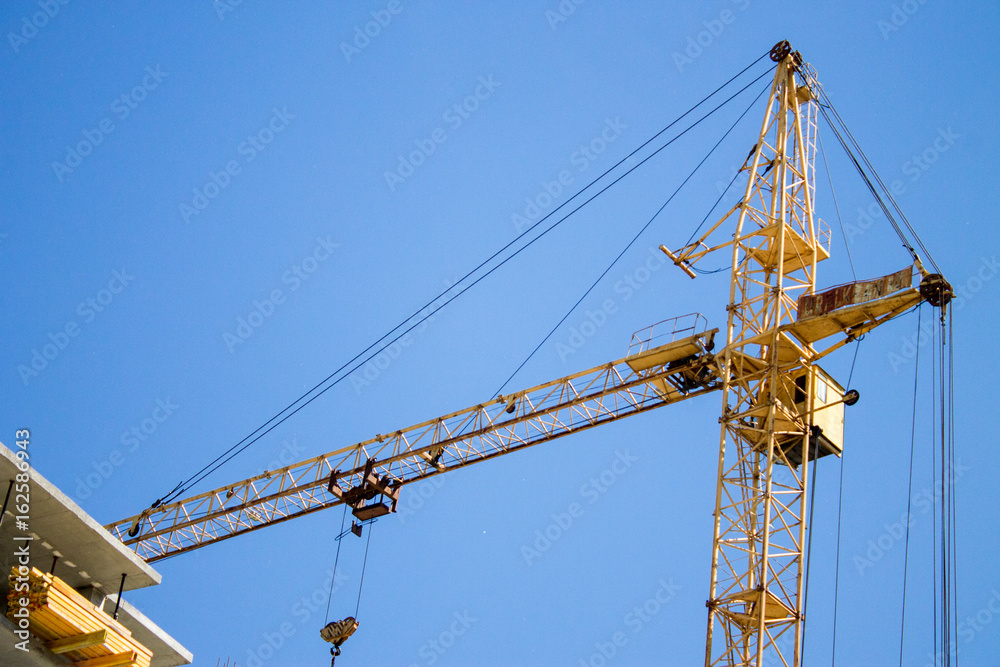 A crane near the building under construction. Novosibirsk, Russia, June 2017. A crane near the building under construction. Novosibirsk, Russia, June 2017.