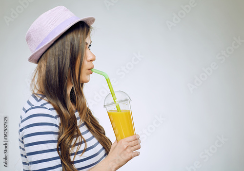 Young smiling woman holding orange juice glass.