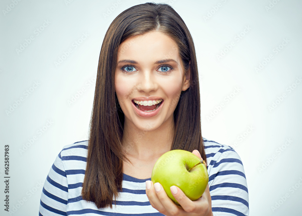 Happy girl with dental braces holding green apple. Happy girl with dental braces holding green apple.