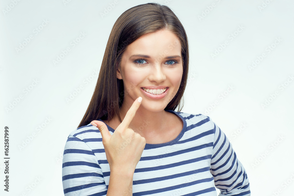 Smiling girl pointing finger on dental braces. Smiling girl pointing finger on dental braces.