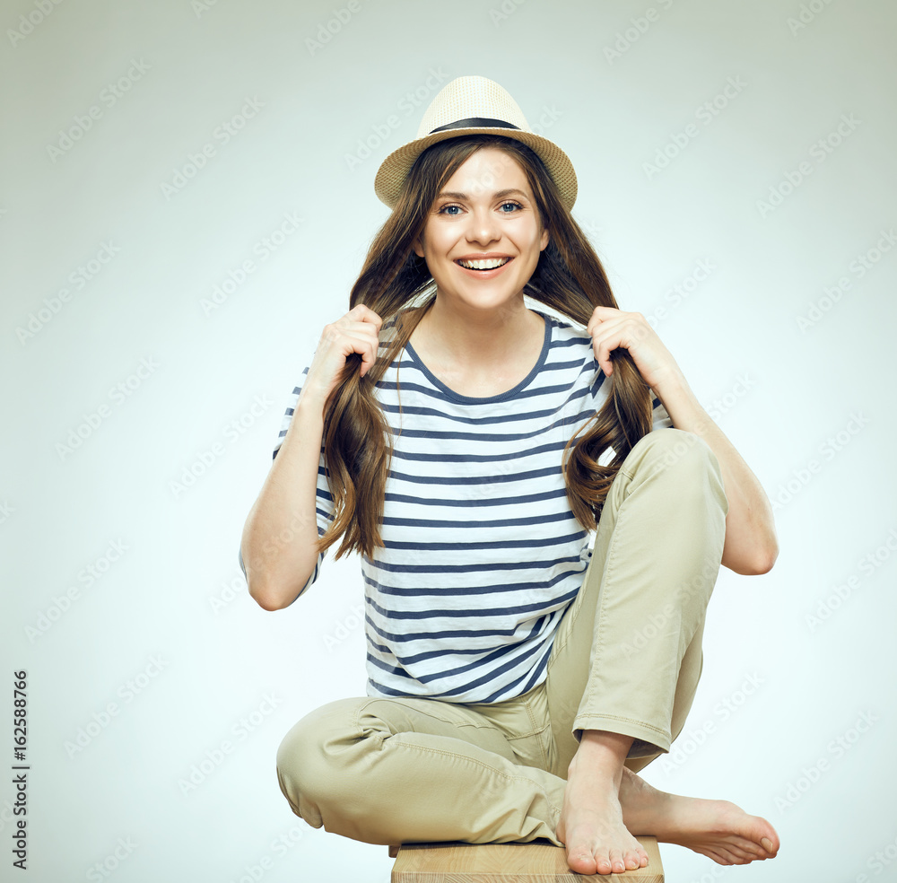 Beautiful young woman sitting relaxed wearing modern hat. Beautiful young woman sitting relaxed wearing modern hat.