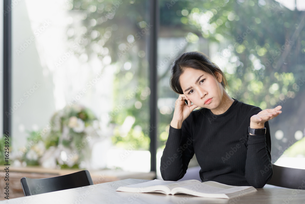 Portrait of a doubtful asian woman student college looking at camera, reading book. Portrait of a doubtful asian woman student college looking at camera, reading book.