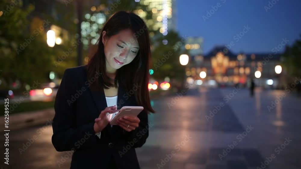 Business woman working on smart phone in city of tokyo Business woman working on smart phone in city of tokyo