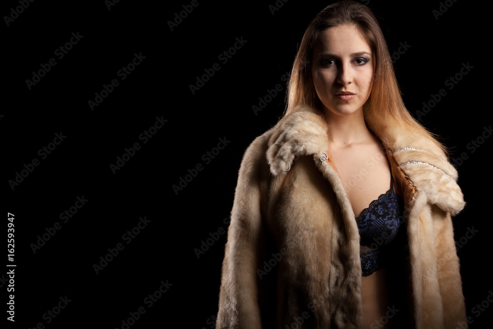 Hot sexy woman in fur and bra on black background in studio photo. Erotic attractive model Hot sexy woman in fur and bra on black background in studio photo. Erotic attractive model