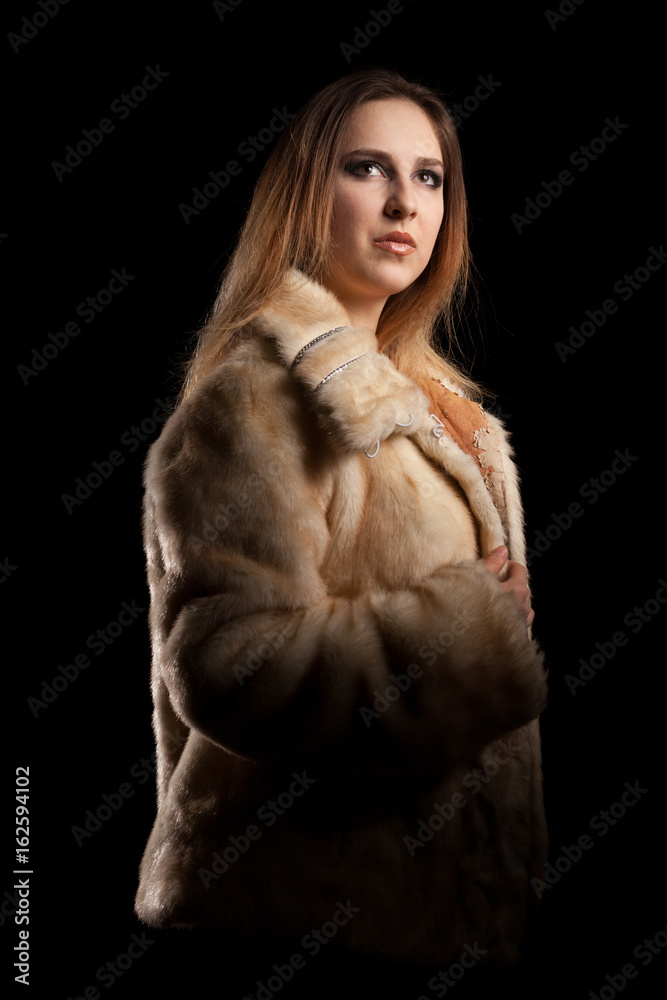 Hot sexy woman in fur and bra on black background in studio photo. Erotic attractive model