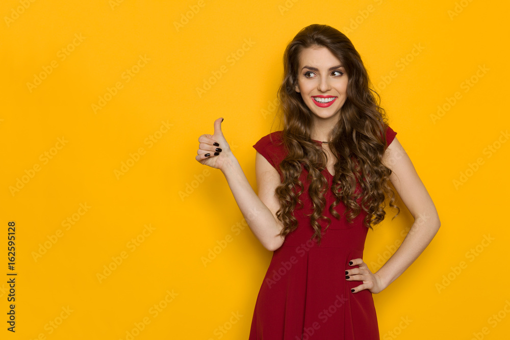 Young Woman In Burgundy Dress Is Showing Thumb Up Young Woman In Burgundy Dress Is Showing Thumb Up
