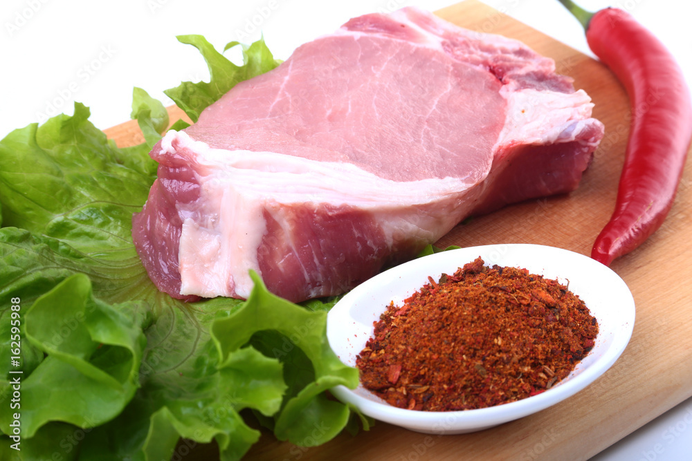 Raw pork chops with herbs and spices on cutting board. Ready for cooking. Raw pork chops with herbs and spices on cutting board. Ready for cooking.