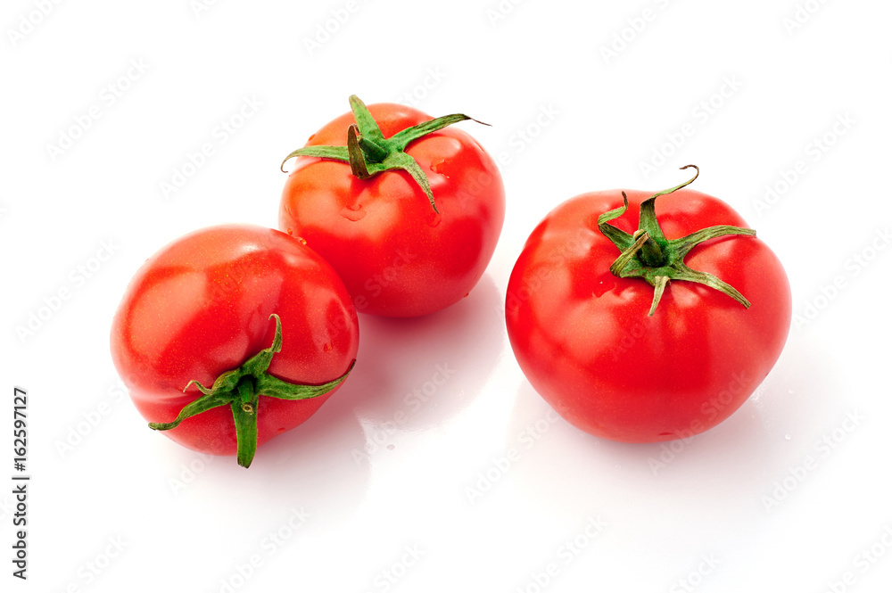 Three red ripe tomatoes with water drops isolated on white background. Top view.