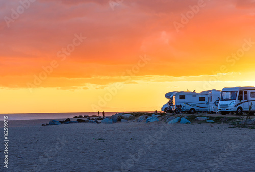 Motor homes, camper vans at sunset beach.Travel adventure vacation.