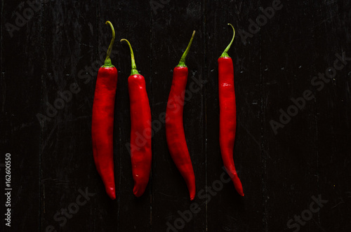 red chili peppers on black background top view