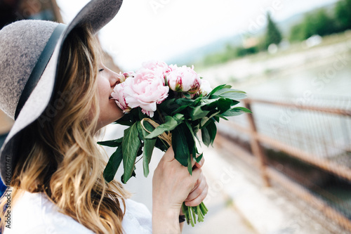 Beautiful woman holding a bunch of peony flowers photo