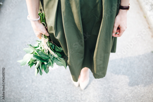 Beautiful woman holding a bunch of peony flowers photo