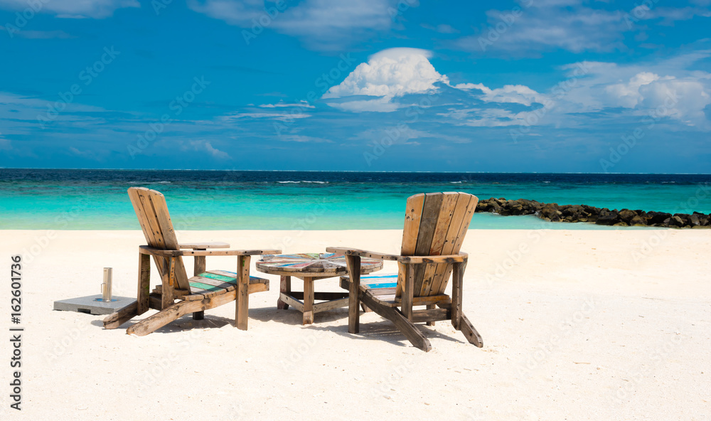 wooden chairs on a tropical beach